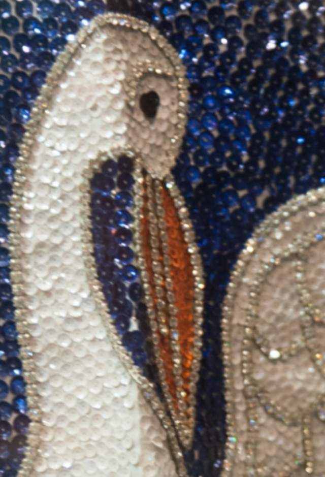 Close-up photo of beautiful sequin mosaic of white bird with two baby birds