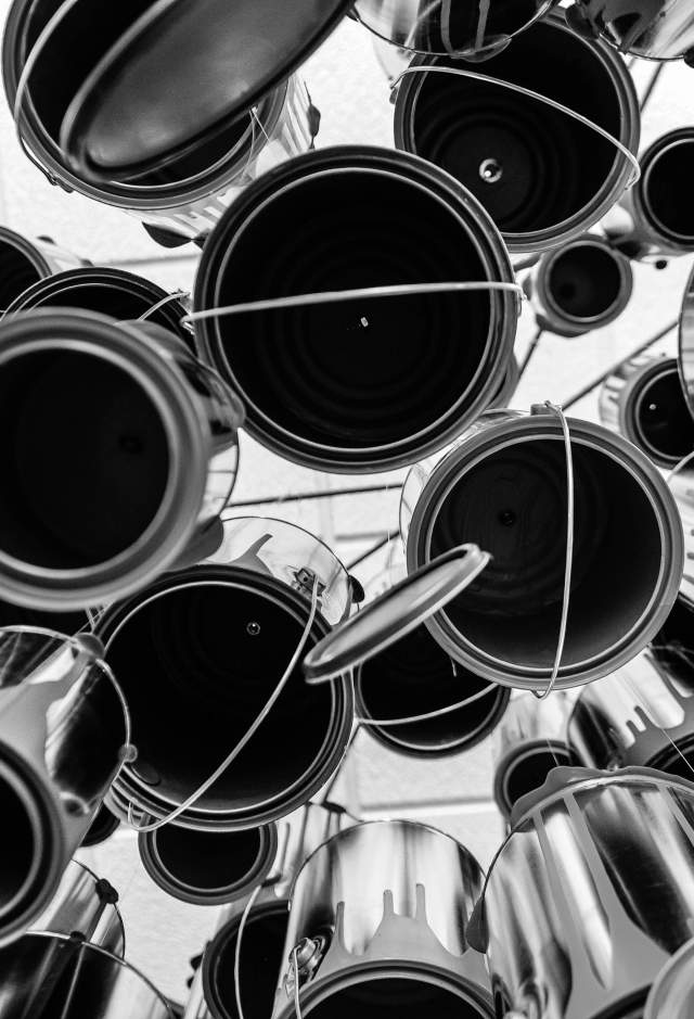Art installation of dangling white paint cans photographed from below