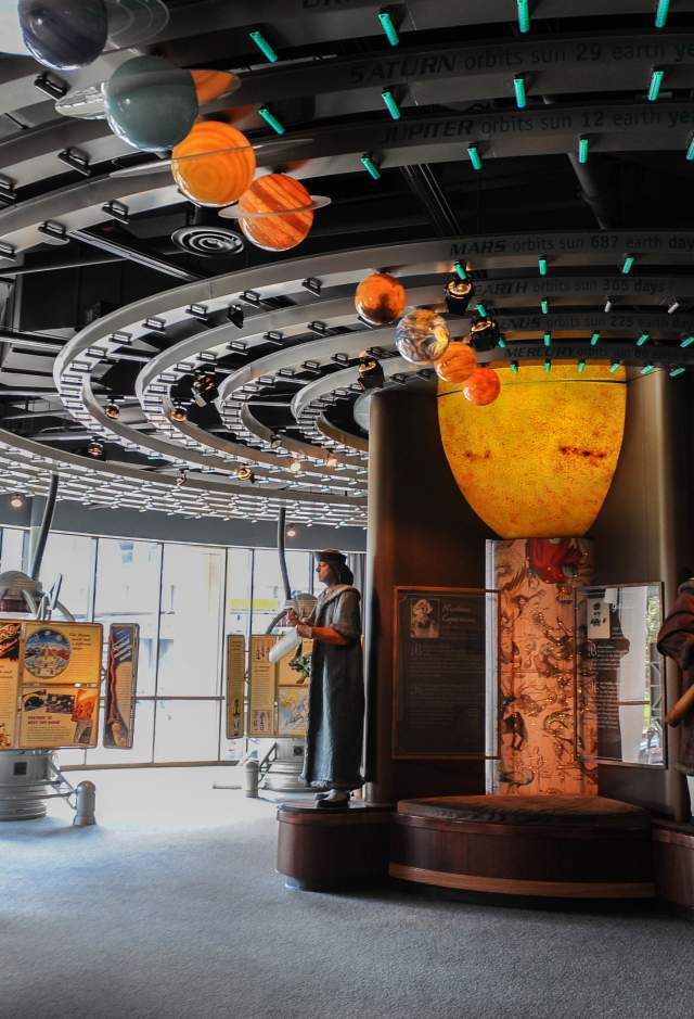 Statues and a large mobile model of the solar system are part of an exhibit at LASM.