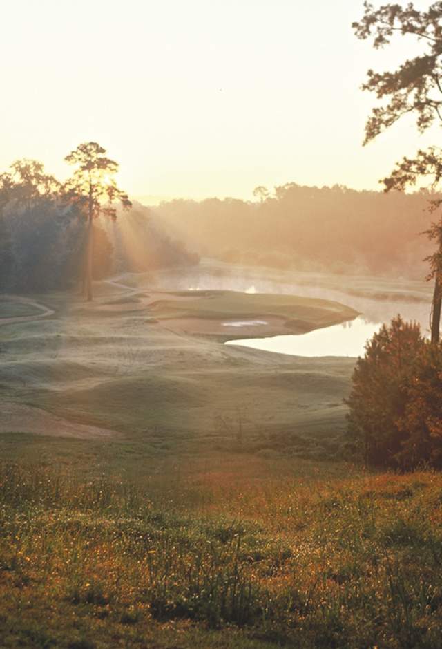 Sunlight filters in through the early morning mist over the green at The Bluffs Golf Resort, north of Baton Rouge.